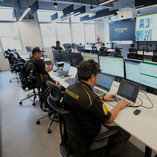 Security analysts monitoring data and network activity on multiple screens inside a Prosegur control room