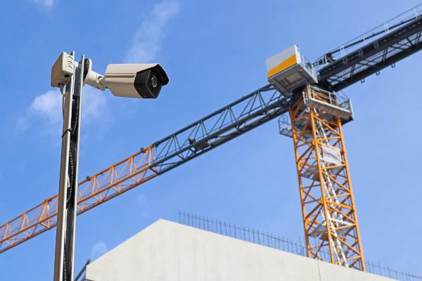 A security camera operating at a construction site with a crane in the background