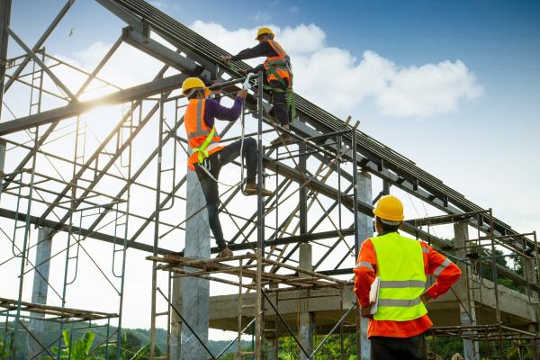 Workers at a construction site climbing on equipment