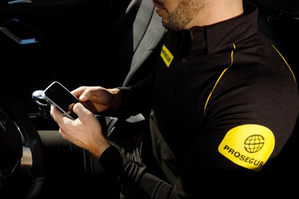 A Prosegur security officer using his phone to log information