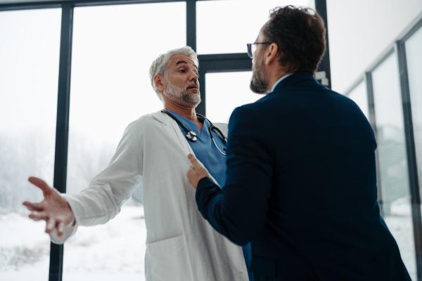 A man being aggressive towards a doctor