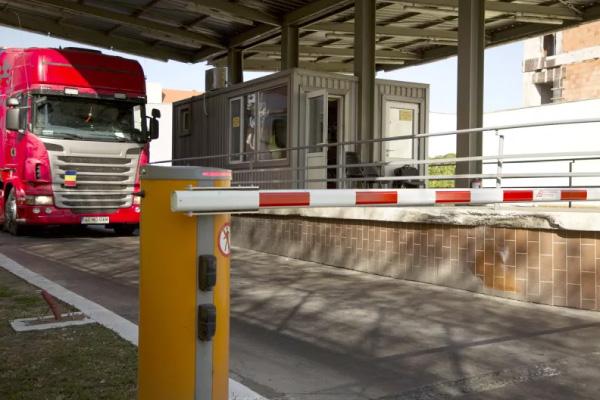 A commercial truck waiting at a security checkpoint to exit a truckyard