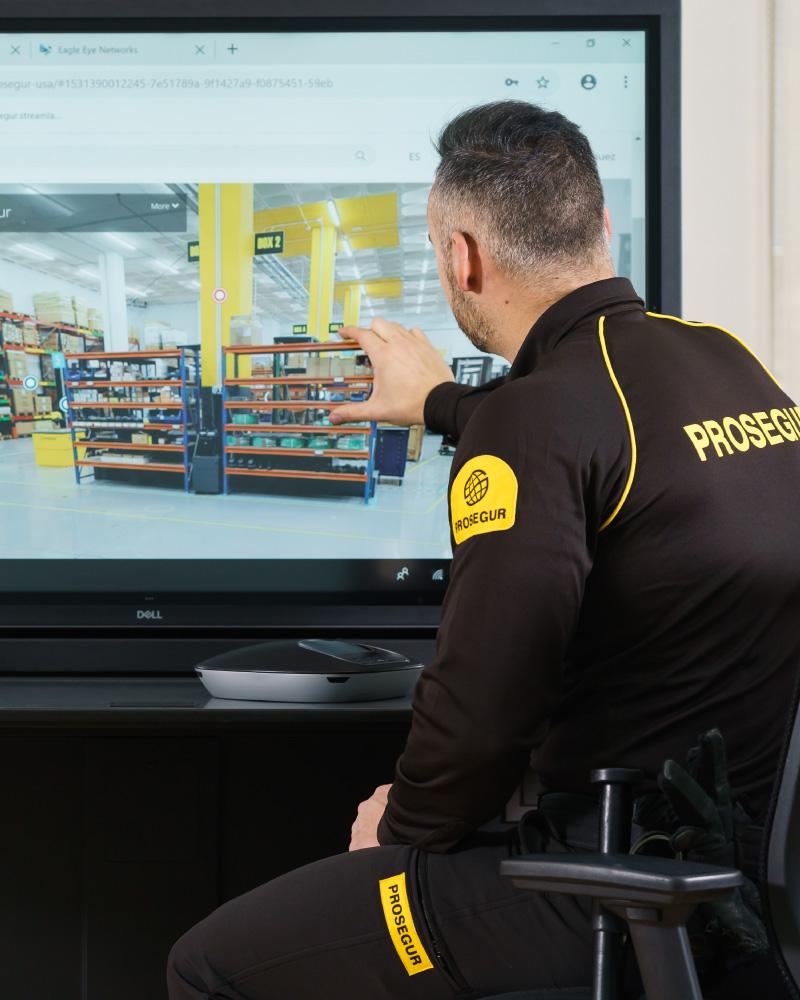Retail Remote Security Monitoring A Prosegur security guard reviewing camera footage in a retail space