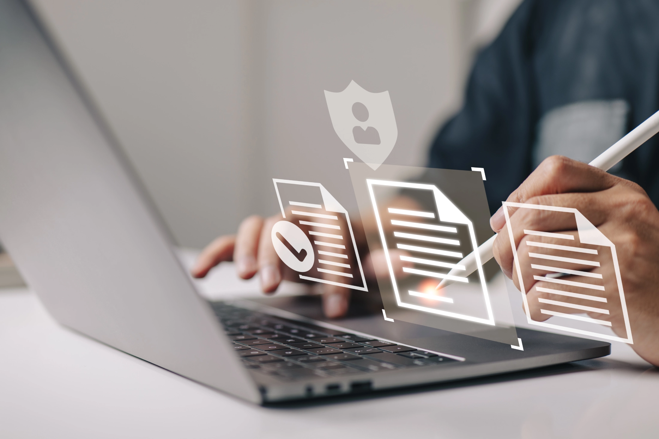 Hands utilizing a laptop featuring interactive holographic icons for secure document management and corporate auditing